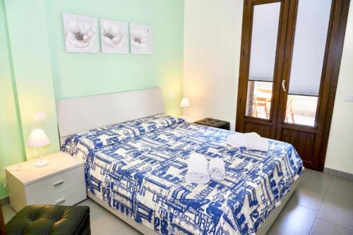 una camera da letto con un letto con un piumone blu e bianco di Perla Blu a Cefalù