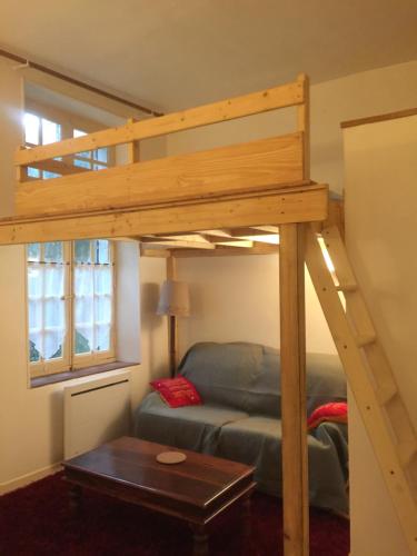 1 cama elevada en una sala de estar con sofá en Cosy, calme et authentique au coeur de ville, en Carcassonne