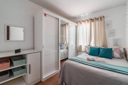 a white bedroom with a bed and a mirror at Family Space Curitiba/vaga de garagem Gratis in Curitiba