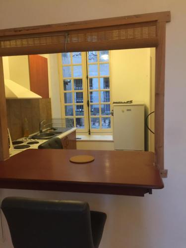 Una cocina con una mesa de madera y un refrigerador. en Cosy, calme et authentique au coeur de ville, en Carcassonne