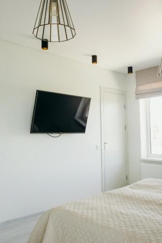 a bedroom with a flat screen tv on the wall at Green Town in Vievis