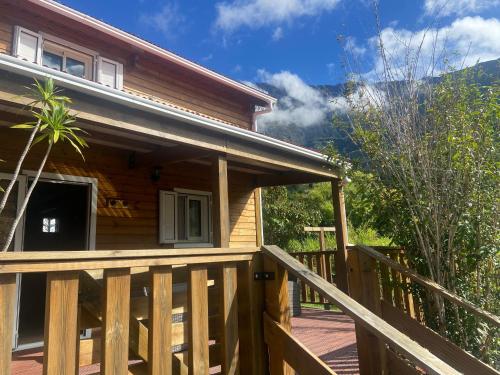 a log cabin with a porch and a deck at La CAFRINE in Cilaos