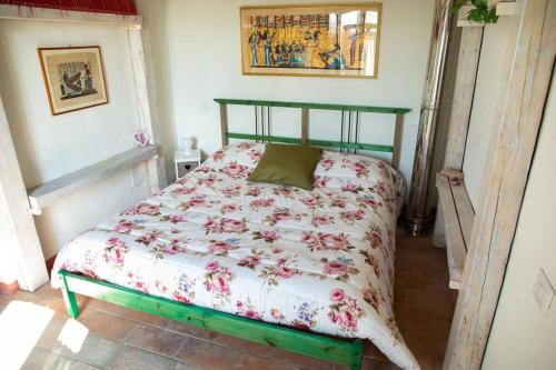 聖塞波爾克羅的住宿－Antico Casello *un'oasi di pace a Sansepolcro*，卧室内的一张带花卉棉被的床