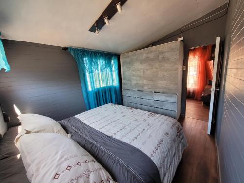 コキンボにあるMi Estanciaのベッドルーム(ベッド1台、青いカーテン付)