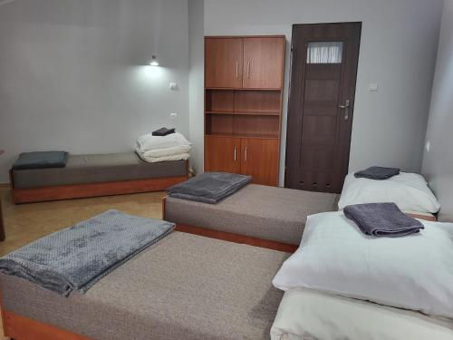 a room with three beds and a closet at Hotelik OSiR Lubawa in Lubawa