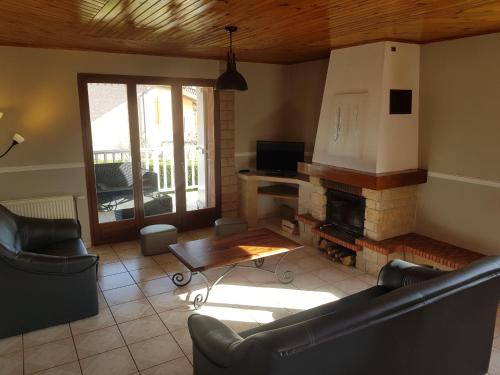 a living room with couches and a fire place at Grand Appartement avec cheminée dans maison, parking gratuit in Mionnay