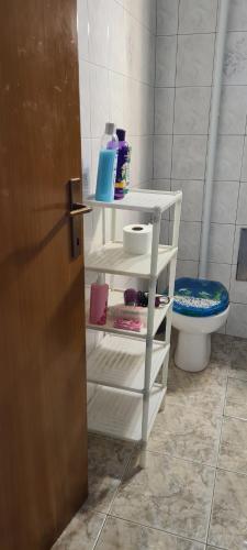 - une salle de bains avec une étagère blanche à côté de toilettes dans l'établissement SmartStar, à Split