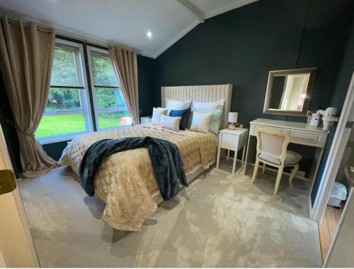 a bedroom with a bed and a desk and a window at The Lodge at Haggerston Castle in Beal