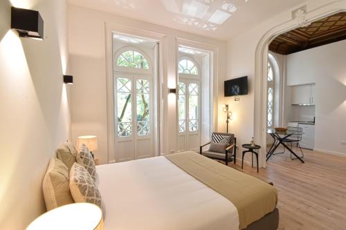 een slaapkamer met een bed en een woonkamer bij LAA Studios in Coimbra