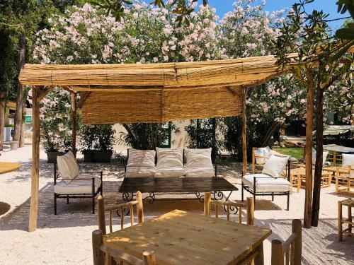 a wooden gazebo with a table and chairs and a table and chairs at Baia Dei Micenei in Otranto