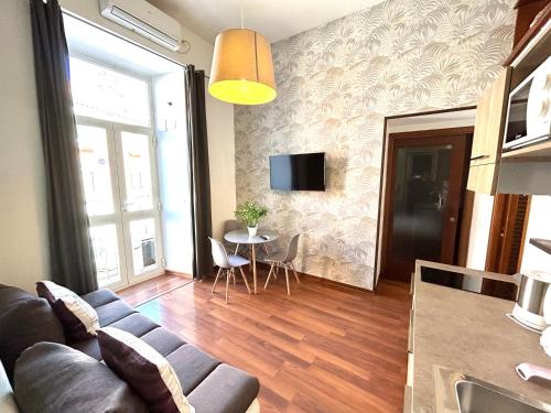 uma sala de estar com um sofá e uma mesa em Maison Plebiscito em Nápoles