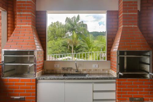 a kitchen with a window with a view of a palm tree at Pousada Recanto da Paz in Lindóia