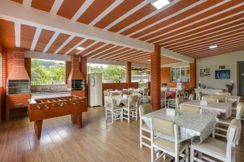 a restaurant with tables and chairs and a kitchen at Pousada Recanto da Paz in Lindóia