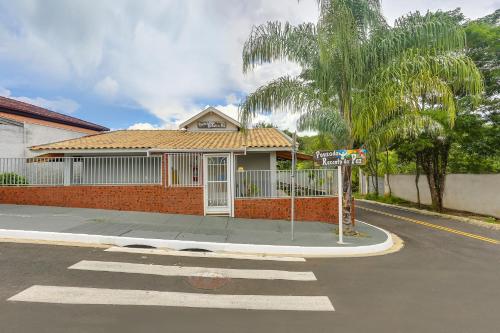 una casa en la esquina de una calle con un letrero en Pousada Recanto da Paz, en Lindóia