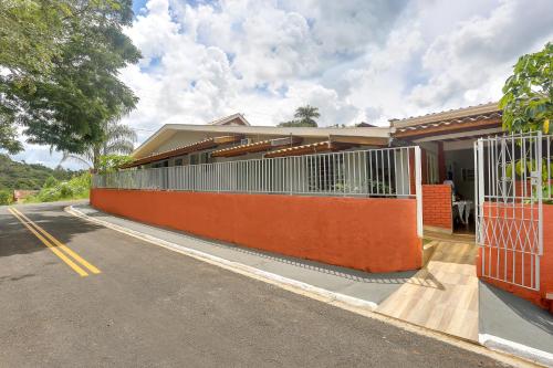 a house with an orange fence next to a street at Pousada Recanto da Paz in Lindóia