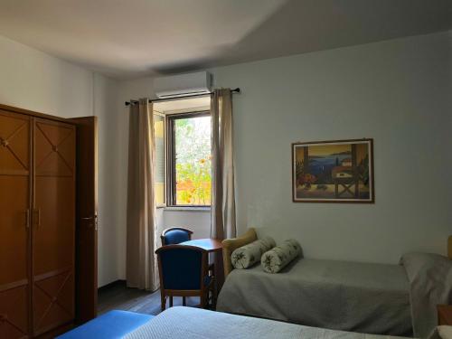 a room with two beds and a table and a window at Hotel d'Orleans in Palermo