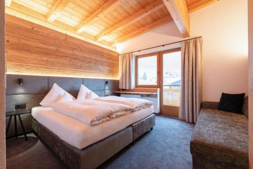 Un dormitorio con una cama grande y una ventana en Hotel Garni Feuerstein, en Sankt Anton am Arlberg