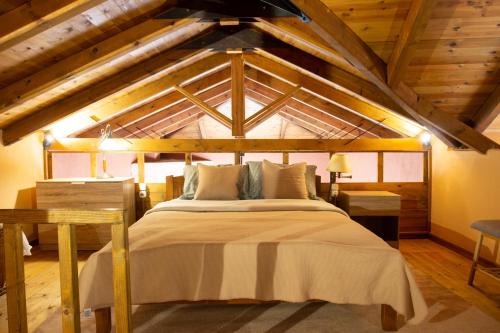 uma cama grande num quarto com tectos em madeira em Passenger Point em Volos