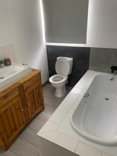a bathroom with a toilet and a sink and a tub at Family fun in Vaal Marina in Vaal Marina
