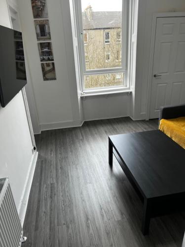 a living room with a coffee table and a window at Wellington Apartment in Glasgow