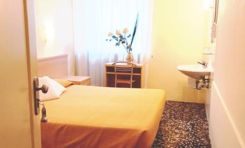 a hotel room with two beds and a sink and a bathroom at Hotel Santa Lucia in Venice