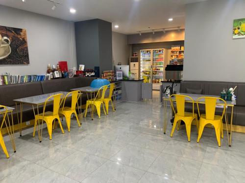 a restaurant with yellow chairs and tables and a counter at B70 HC Rental Apartment at TK Central with Swimming Pool & Gyms in Phnom Penh