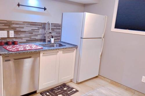 a kitchen with a white refrigerator and a sink at *Luxury 1 BR Suite - Own Access* in Sherwood Park