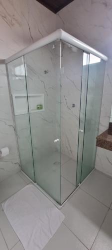 a glass shower in a bathroom with marble walls at Pousada Litorânea in São Luís
