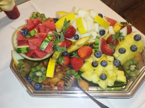 a tray of fruit on a table with a fork at Hotel Cranach-Herberge City Centre in Lutherstadt Wittenberg