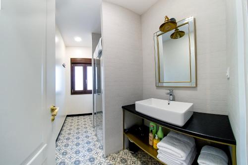 a bathroom with a sink and a mirror at Cervantes5Collection Delux Alcazar in Toledo
