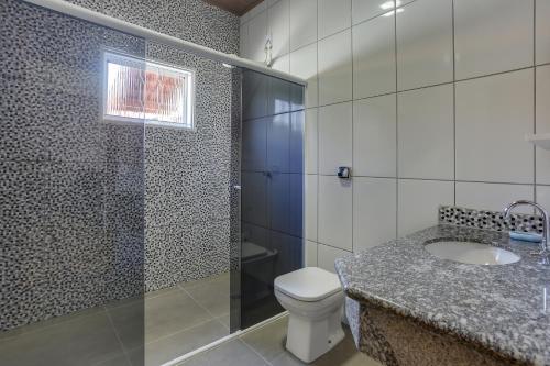 y baño con ducha, aseo y lavamanos. en Casa São Luis, en Lindóia