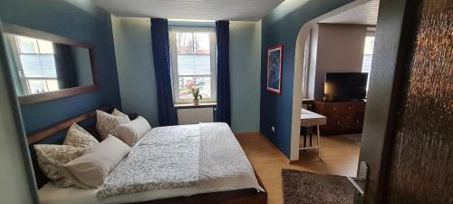 a bedroom with a white bed and a blue wall at charming oldtown city in Worms