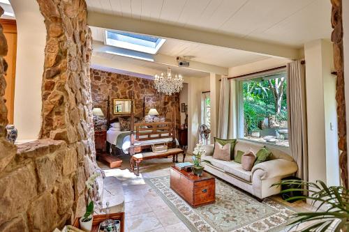 a living room with a stone wall at MacLeod House Guest Cottage in Kloof