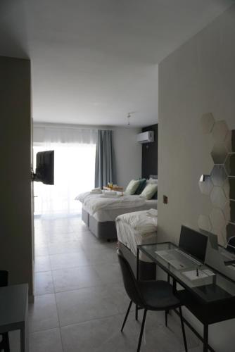 um quarto de hotel com duas camas, uma secretária e uma mesa em KORZO SUITES em Il-Gżira
