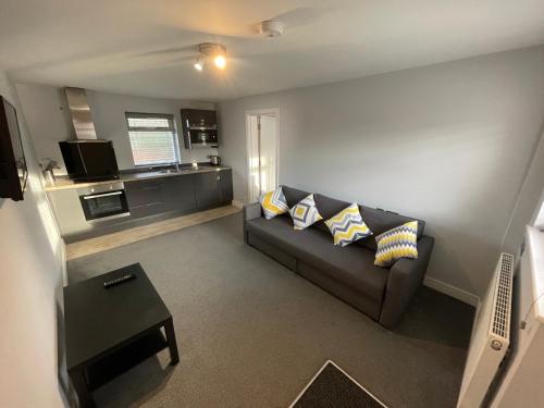 a living room with a couch and a kitchen at Arlan House, Central Basingstoke Hotel in Basingstoke