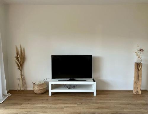 een woonkamer met een tv op een witte tafel bij Wohnglück Seifferer in Ravensburg