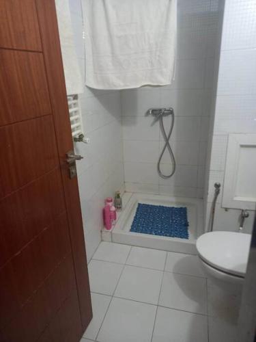 a bathroom with a shower with a blue floor at Appartement plein Centre Urbain in Tunis