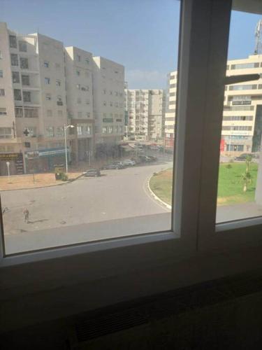 - une fenêtre donnant sur une rue avec des bâtiments dans l'établissement Appartement plein Centre Urbain, à Tunis