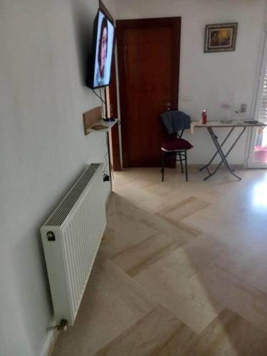 a living room with a radiator and a tv on a wall at Appartement plein Centre Urbain in Tunis