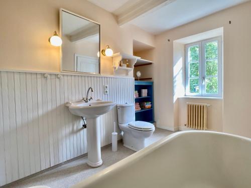 ein Badezimmer mit einer Badewanne, einem WC und einem Waschbecken in der Unterkunft Hübsches Landhaus der Familie mit eigenem Garten in Heugueville-sur-Sienne