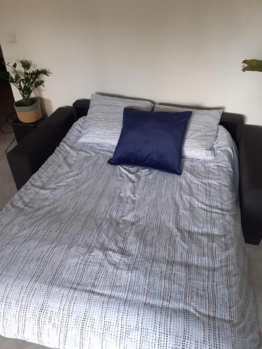 Bett mit blauem Kissen darüber in der Unterkunft Studio Terrasse Proche Palais des Festivals in Cannes