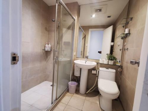 a bathroom with a toilet and a sink and a shower at Elite Pod 5516 Knightsbridge Residences in Manila