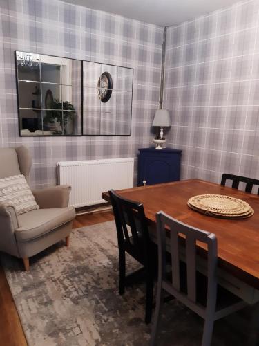 a dining room with a table and a chair at Pondside Cottage in Carmarthen