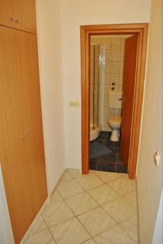 a small bathroom with a toilet and a door at Apartments Buljevic in Vrboska