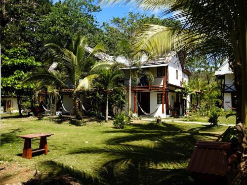 a house with a hammock in front of a yard at La Choza Playa Venao in Playa Venao