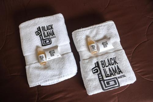 two white towels with blackimmacersomaly at Black Llama Hostel Miraflores in Lima