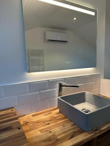 een badkamer met een wastafel en een grote spiegel bij Chez James in Gujan-Mestras