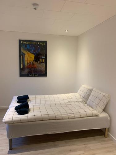 a bed in a room with a picture on the wall at SleepOver in Rødby! Few minutes from Femern Tunnel and Ferry to Puttgarden in Rødby