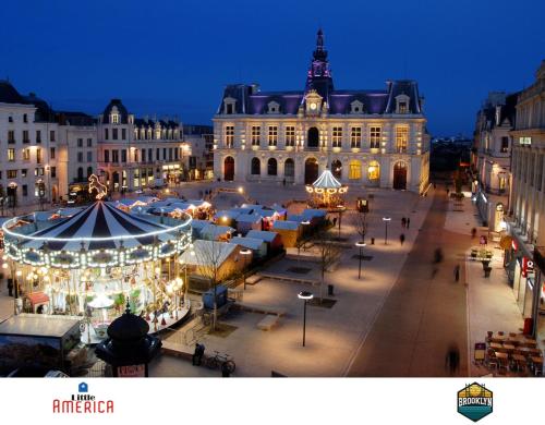 a city with a christmas market in front of a building at Little America - Appart Hôtel 3km Futuroscope in Jaunay-Clan