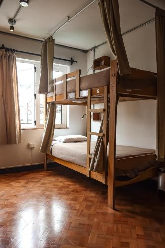 two bunk beds in a room with a wooden floor at Black Llama Hostel Miraflores in Lima